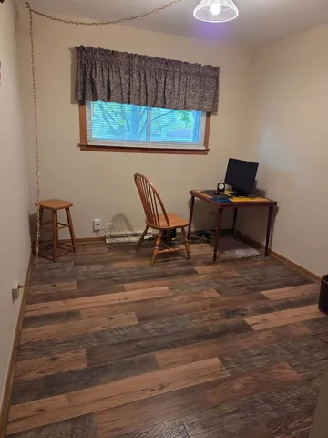 a workspace room with furniture and wooden floor
