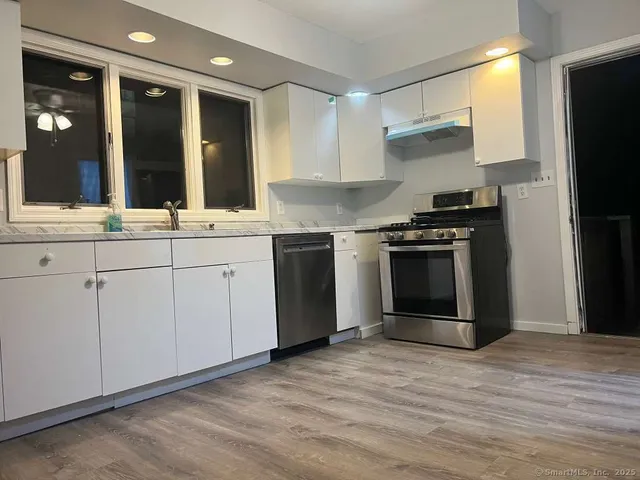 a kitchen with stainless steel appliances granite countertop a stove and a sink