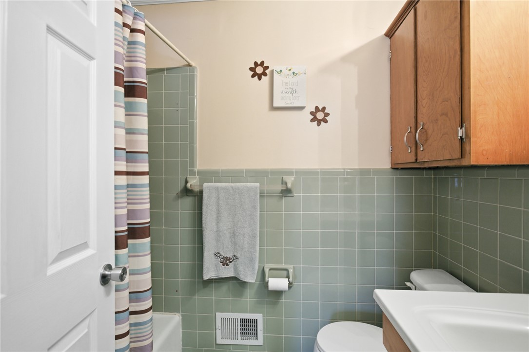 108 Hodge Street Abbeville, SC 29620 - Photo 20 of 39 Timeless green tile wainscoting adds a classic touch to this well-maintained bathroom.