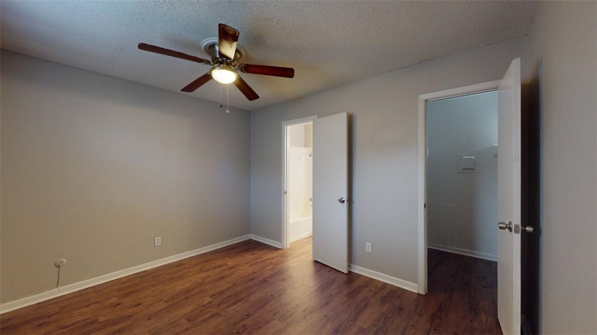 500 Foch Street, Unit 11 Bryan, TX 77801 - Photo 5 of 11 wooden floor in an empty room with a window