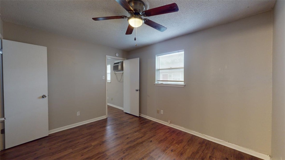 500 Foch Street, Unit 11 Bryan, TX 77801 - Photo 6 of 11 an empty room with wooden floor chandelier fan and windows