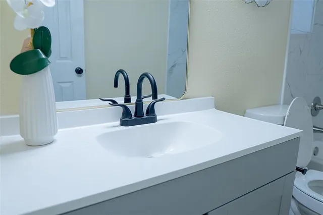 a bathroom with a toilet sink and mirror