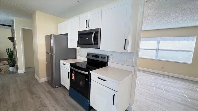 a kitchen with a refrigerator stove and microwave
