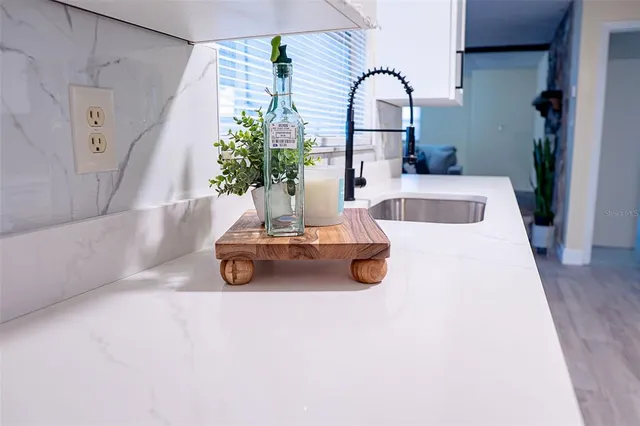 a bedroom with a bed and a potted plant on dresser
