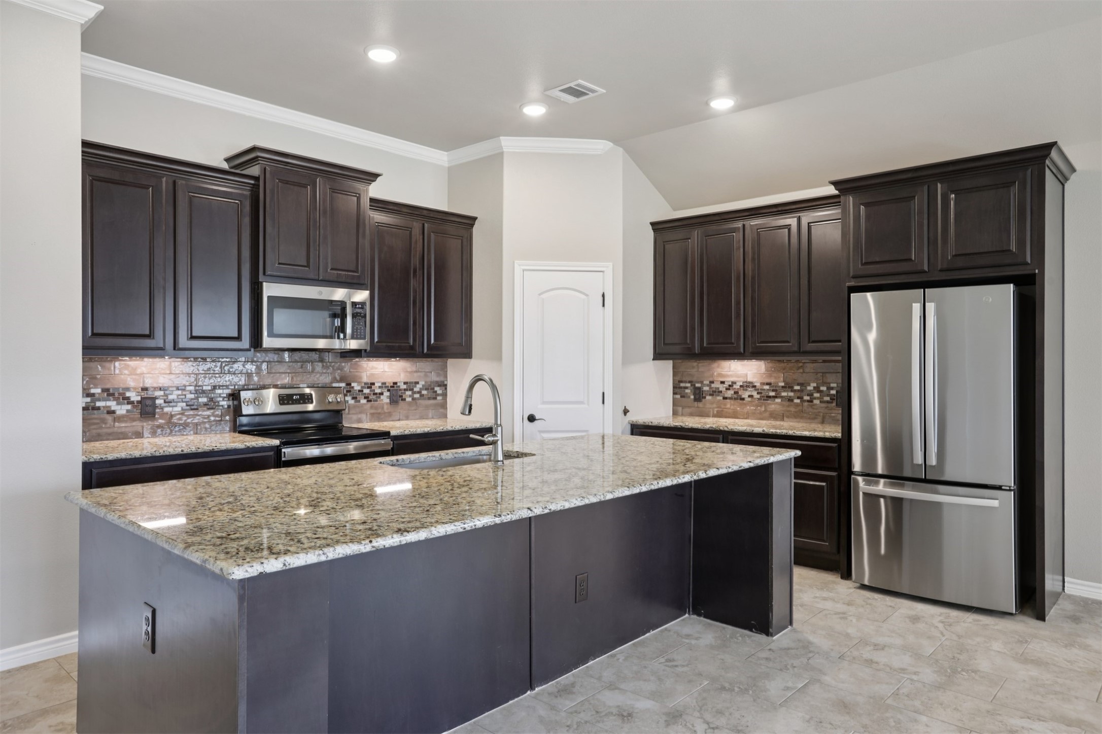 500 Seabiscuit Drive Jarrell, TX 76537 - Photo 11 of 33 a kitchen with stainless steel appliances granite countertop a refrigerator a stove a sink and a microwave