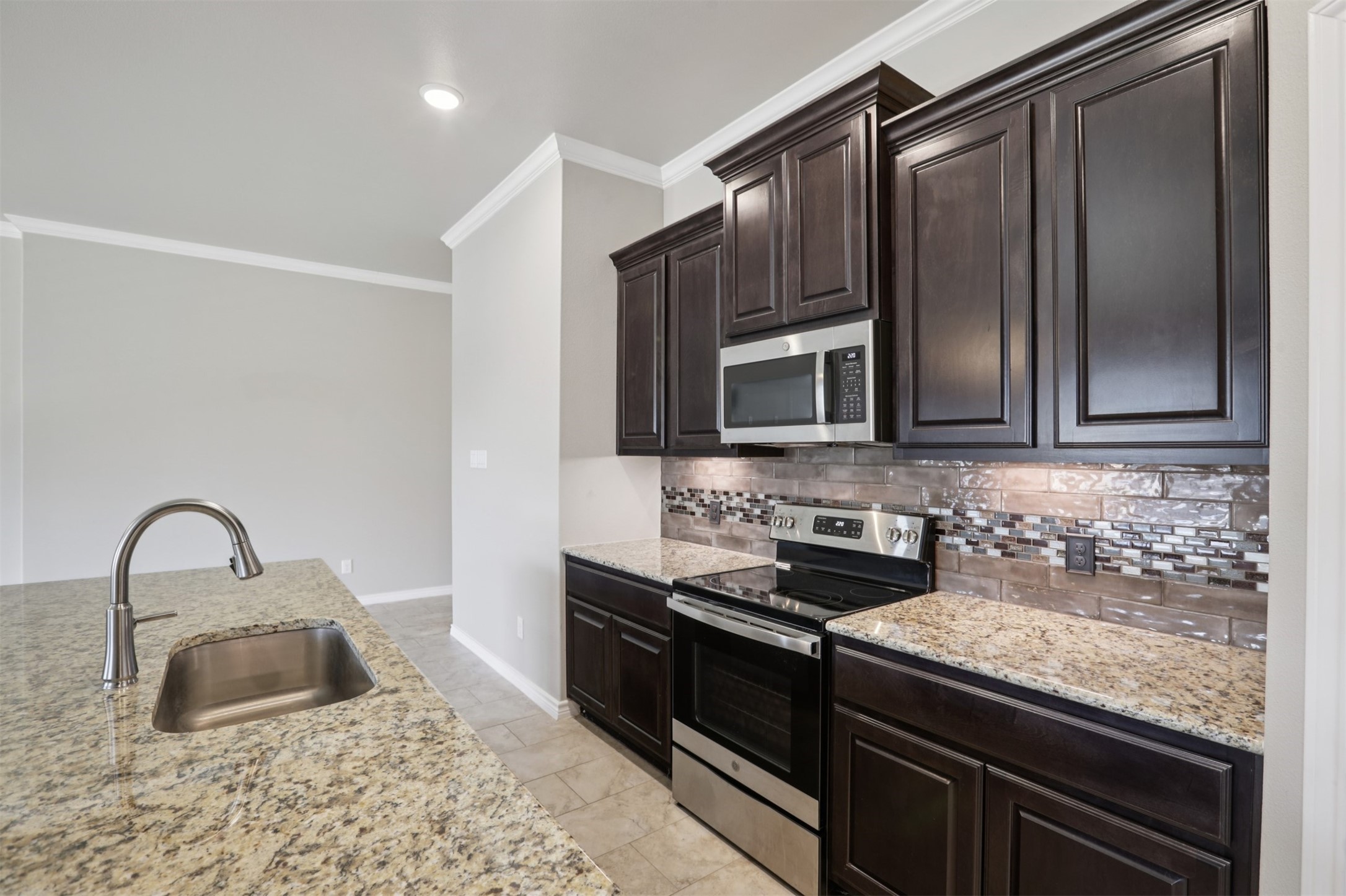 500 Seabiscuit Drive Jarrell, TX 76537 - Photo 12 of 33 a kitchen with granite countertop a sink and stainless steel appliances