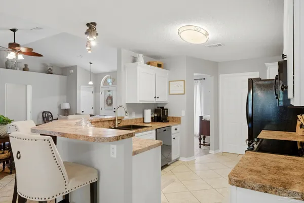 a kitchen with a table chairs sink and cabinets