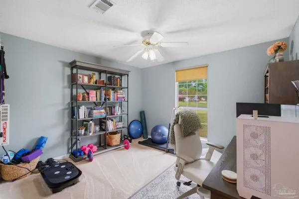 a view of a workspace with furniture and a window