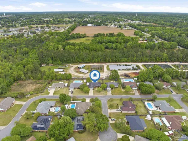 an aerial view of residential houses with outdoor space and trees
