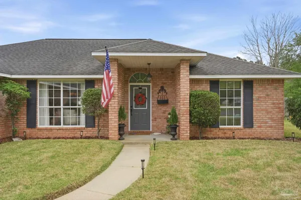 front view of a brick house with a yard
