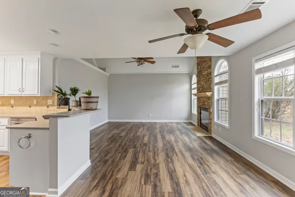 a kitchen with kitchen island white cabinets and black stainless steel appliances