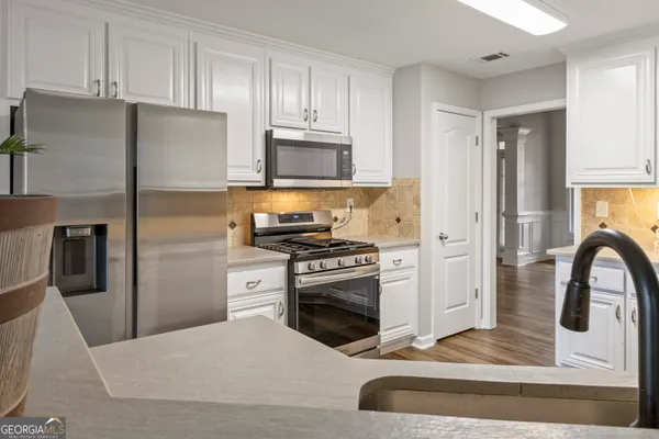 a kitchen with a refrigerator stove and white cabinets