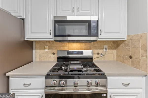 a stove top oven sitting inside of a kitchen
