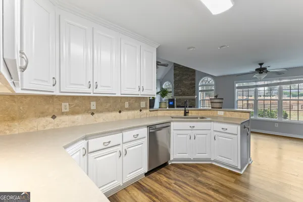 a large kitchen with cabinets and wooden floor