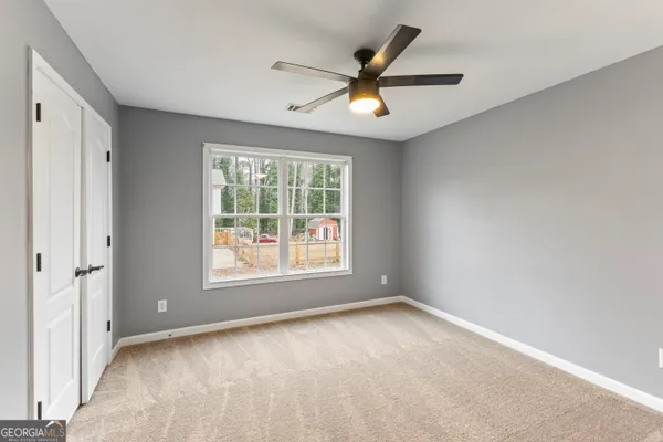 an empty room with a window and a fan