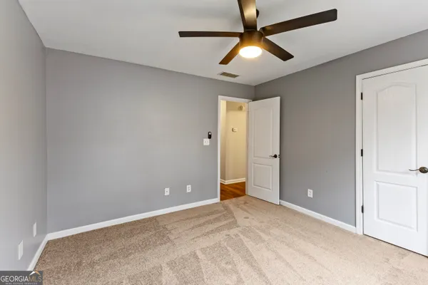 an empty room with chandelier fan