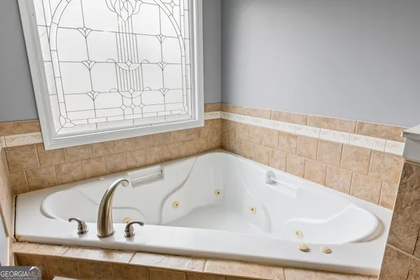 a bathroom with bathtub and window