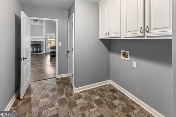 a view of empty room with wooden floor and cabinets