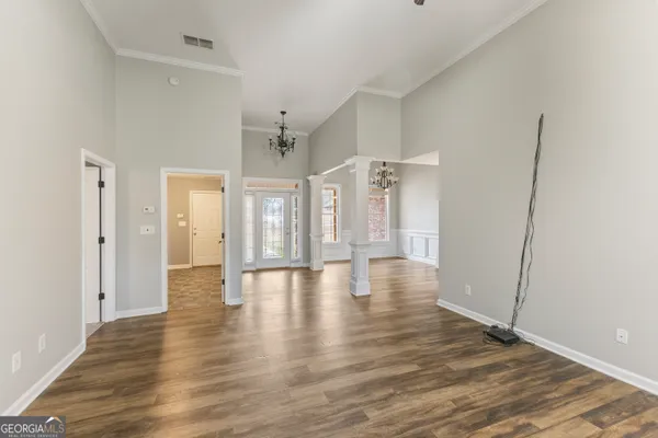 a view of empty room with wooden floor
