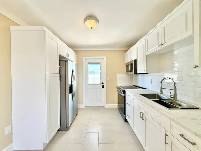 a kitchen with stainless steel appliances granite countertop a sink and a stove