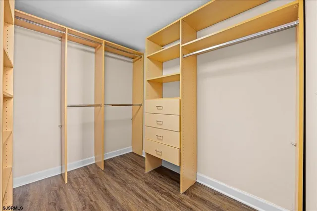 a view of walk in closet with wooden floor