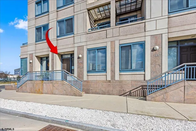 a view of a white building with swimming pool in front of it