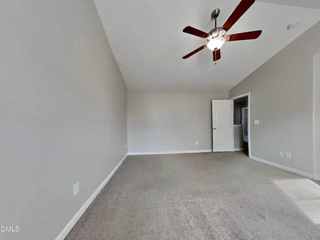 an empty room with ceiling fan and window