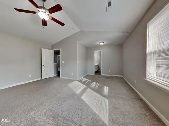 a view of empty room with window and ceiling fan