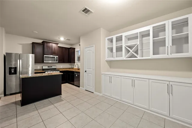 a kitchen with granite countertop stainless steel appliances and refrigerator