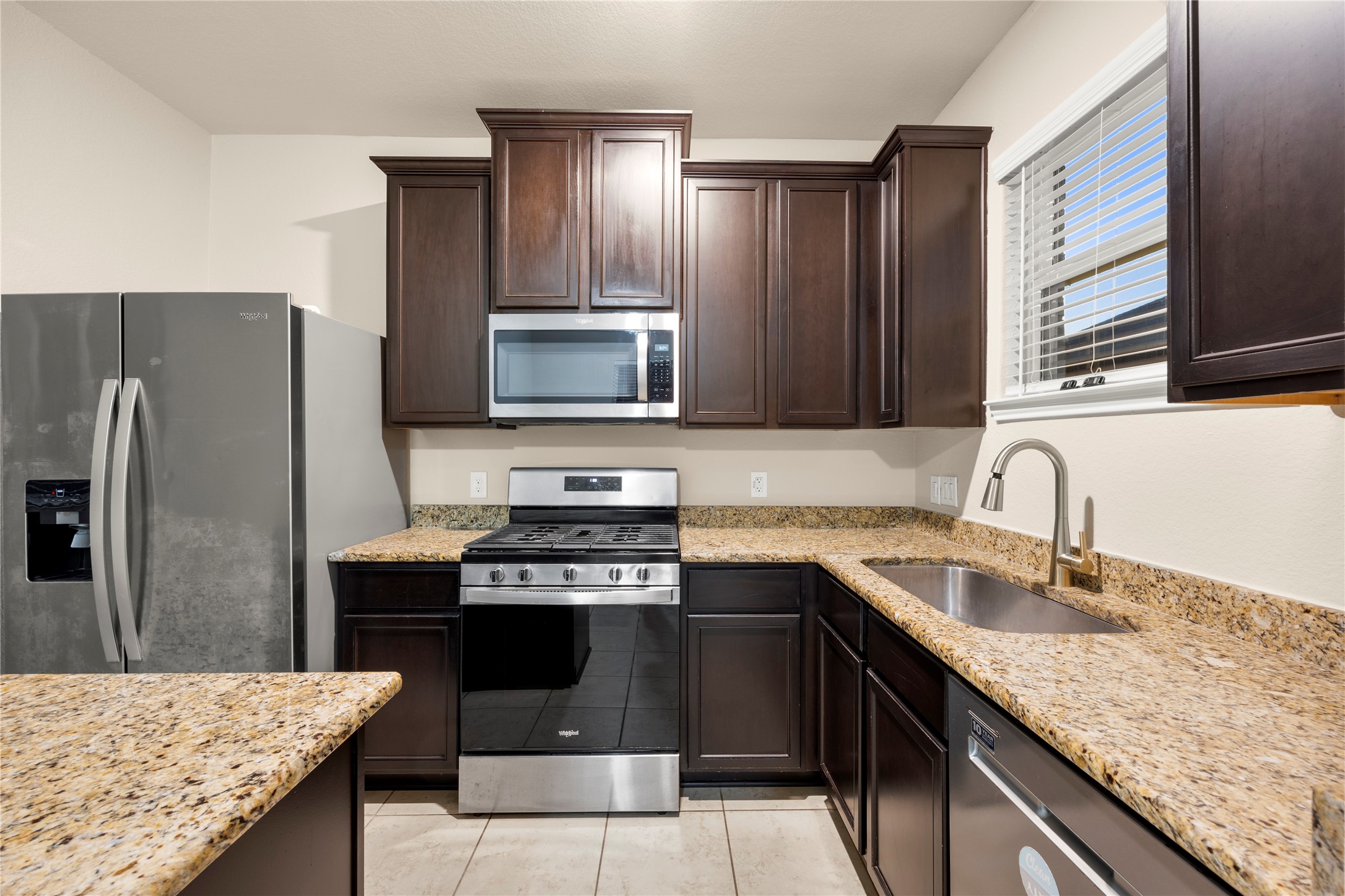 8957 Oval Glass Street Conroe, TX 77304 - Photo 17 of 30 a kitchen with a sink stove and refrigerator