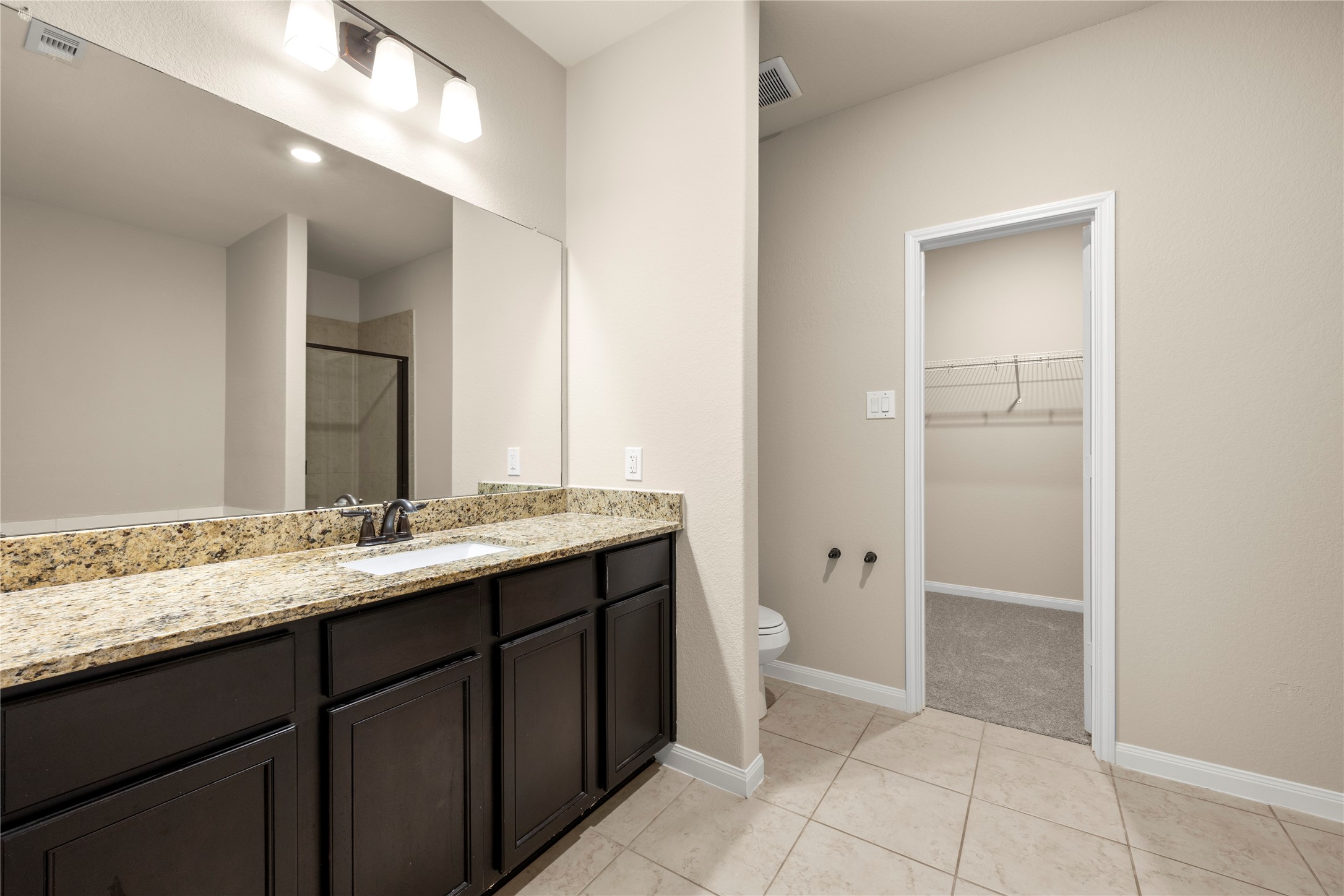 8957 Oval Glass Street Conroe, TX 77304 - Photo 20 of 30 a bathroom with a granite countertop sink and a mirror