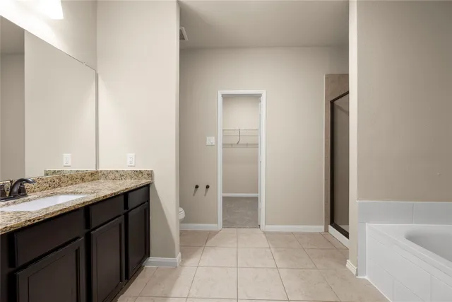 a bathroom with a tub a sink and mirror