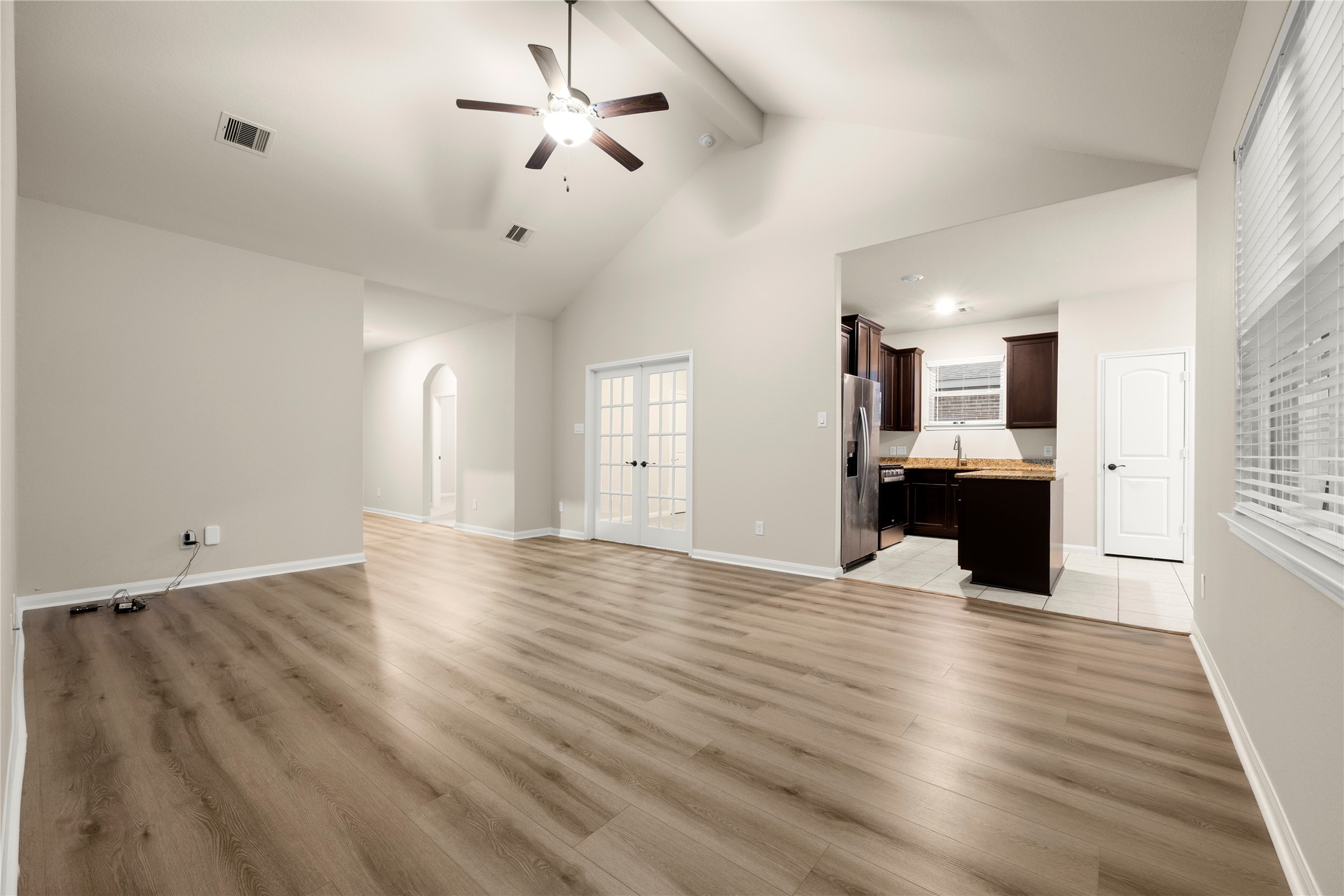 8957 Oval Glass Street Conroe, TX 77304 - Photo 7 of 30 a view of a big room with wooden floor and a kitchen