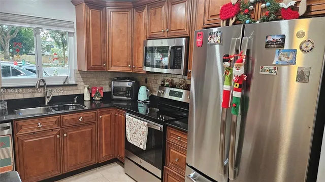 a kitchen with stainless steel appliances granite countertop a refrigerator and a sink