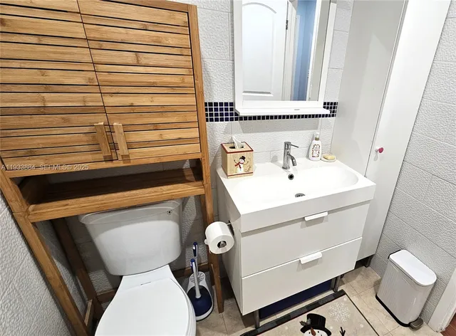 a bathroom with a sink vanity and toilet