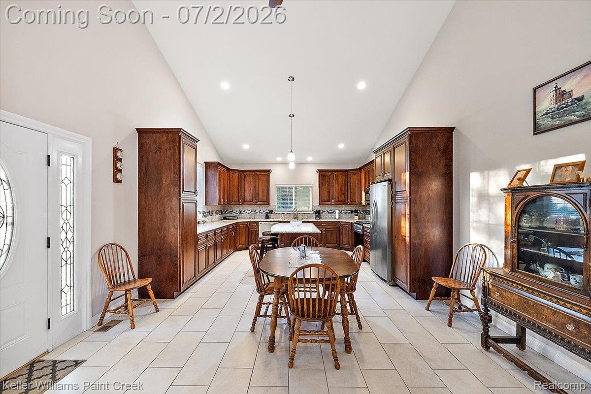 54230 Card Road Macomb, MI 48042 - Photo 33 of 73 Spacious kitchen featuring extensive dark wood cabinetry, light tile flooring, recessed lighting, a kitchen island, and stainless steel appliances