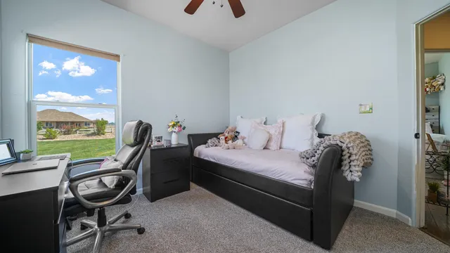 a bedroom with a bed chair and computer on the desk