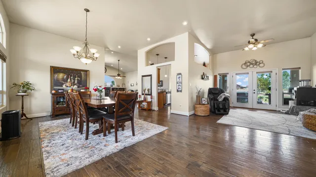 a view of a dining room and livingroom with furniture wooden floor a chandelier