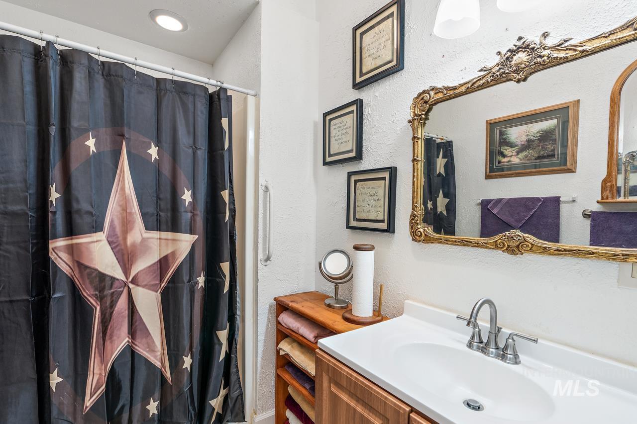 4417 Oak Road Ontario, OR 97914 - Photo 15 of 50 Bathroom featuring a textured wall, vanity, and a shower with curtain