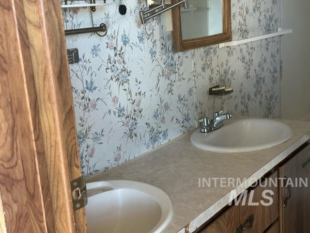4417 Oak Road Ontario, OR 97914 - Photo 37 of 50 Full bathroom featuring wallpapered walls and double vanity