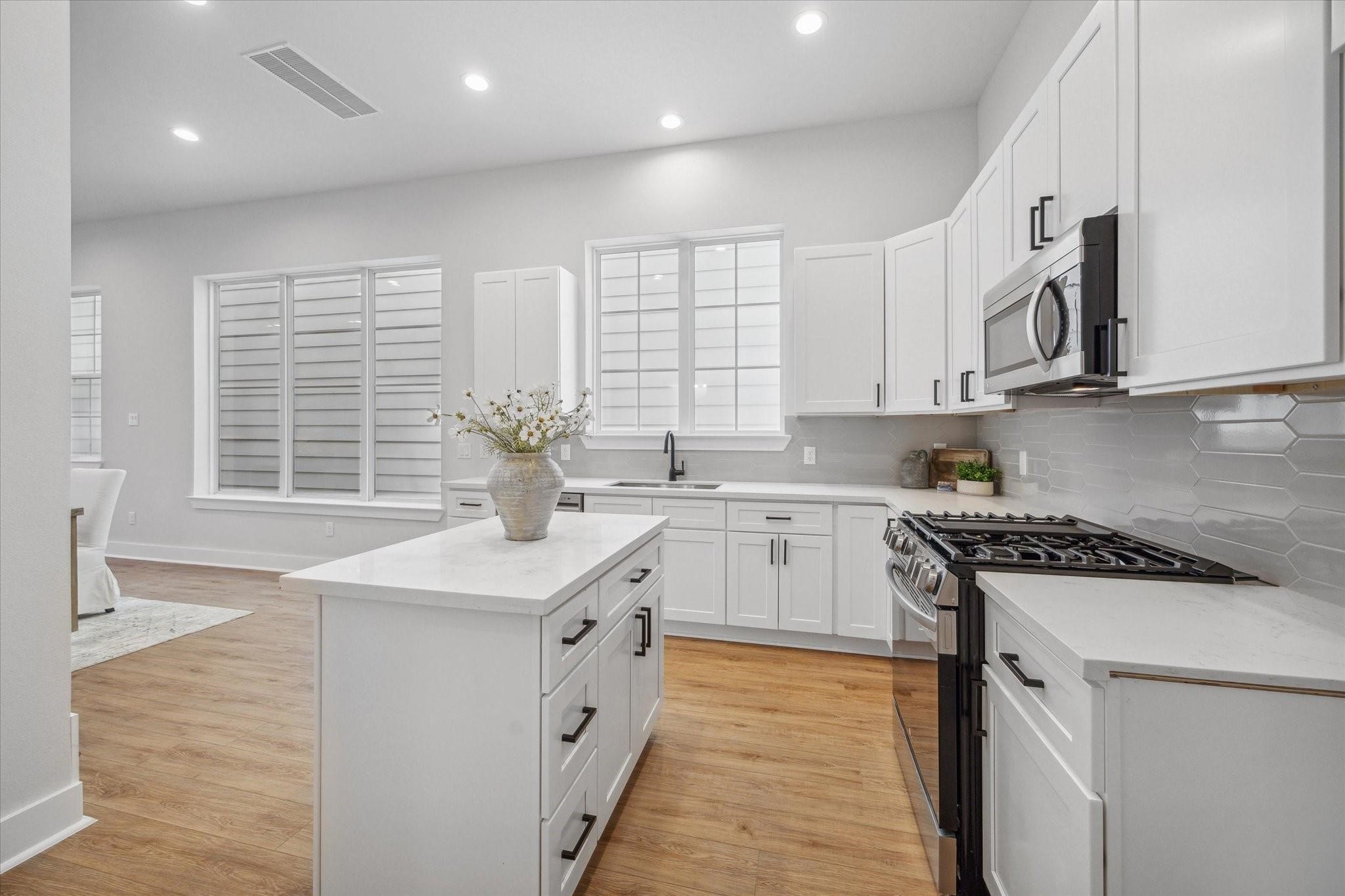1035 West 17th Street Houston, TX 77008 - Photo 9 of 26 a kitchen with stainless steel appliances granite countertop a sink stove and cabinets