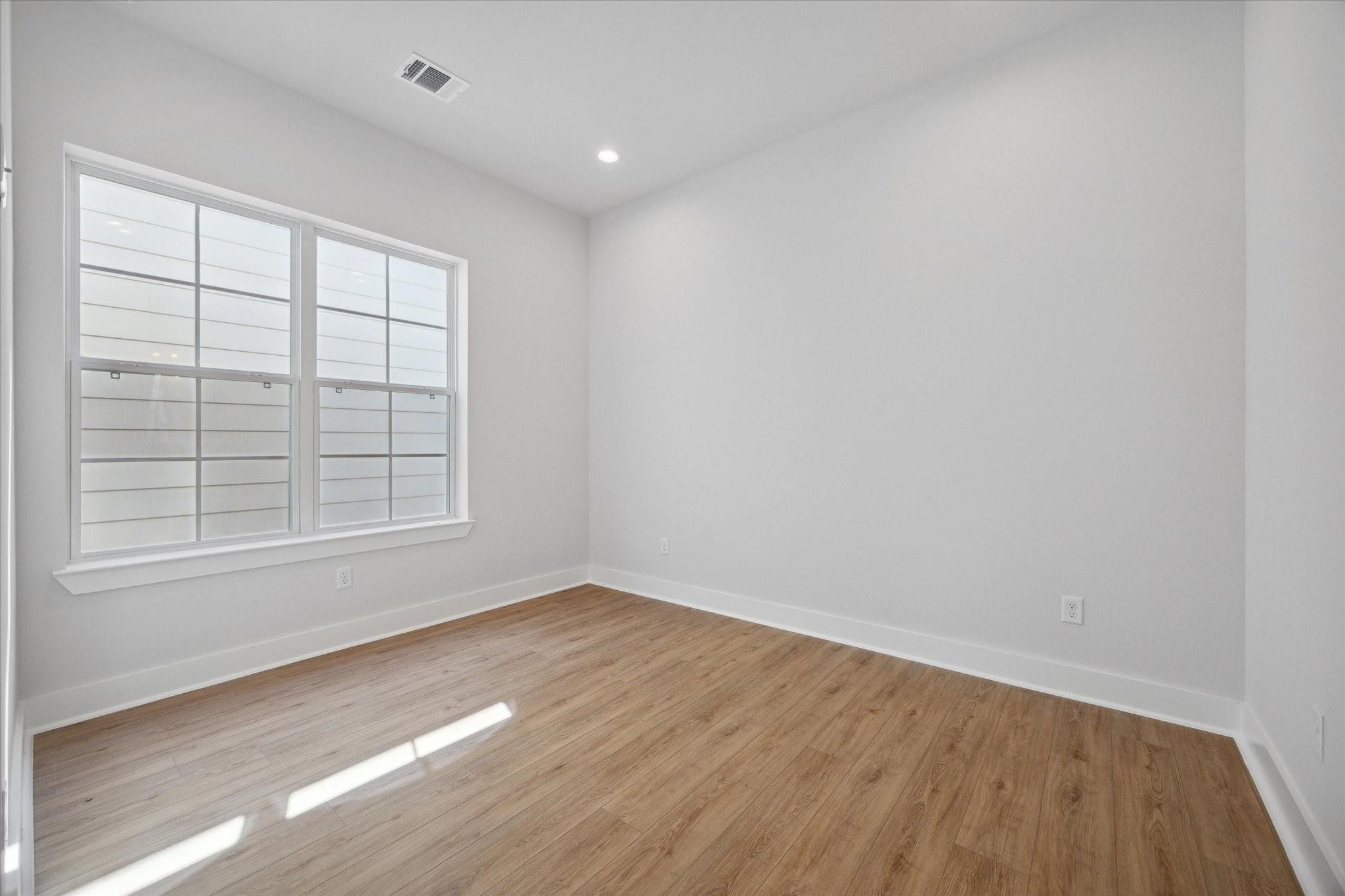 1035 West 17th Street Houston, TX 77008 - Photo 17 of 26 an empty room with wooden floor and windows
