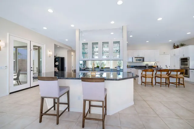 a kitchen with stainless steel appliances kitchen island granite countertop a table and chairs in it