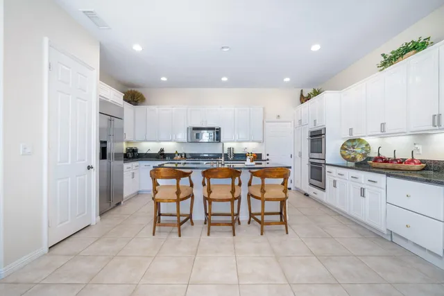a kitchen with stainless steel appliances granite countertop a refrigerator and a stove top oven