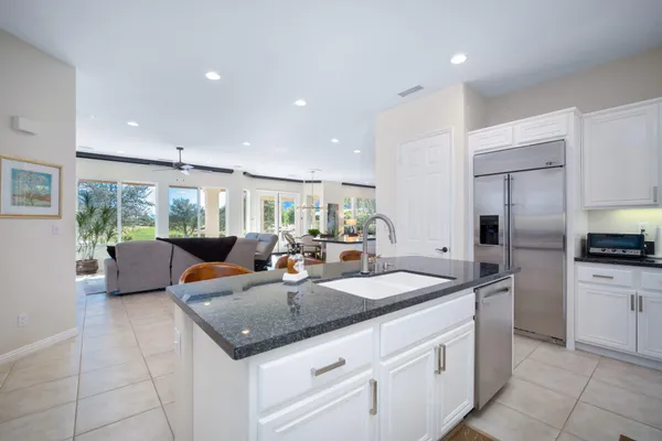 a kitchen with a sink a counter top space appliances and cabinets