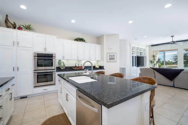 a kitchen with stainless steel appliances granite countertop a kitchen island a stove a microwave a sink and cabinets