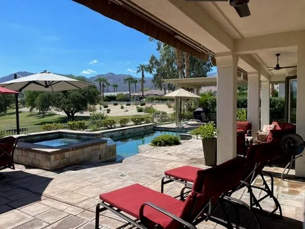a view of a chairs and table in patio with a barbeque grill