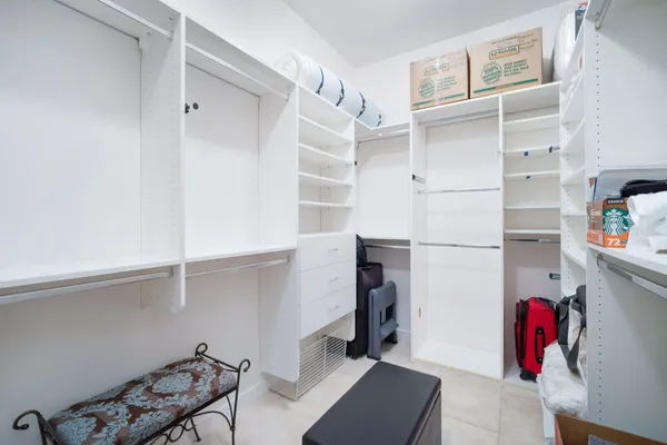 a view of walk in closet with clothes and shoes