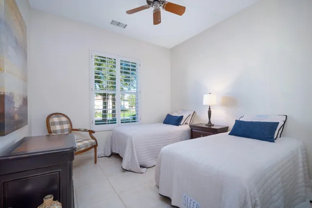 a bedroom with two bed and a large window