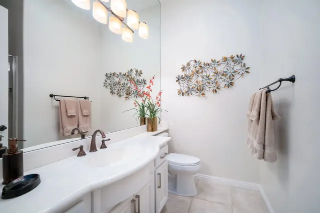 a bathroom with a sink vanity granite and toilet